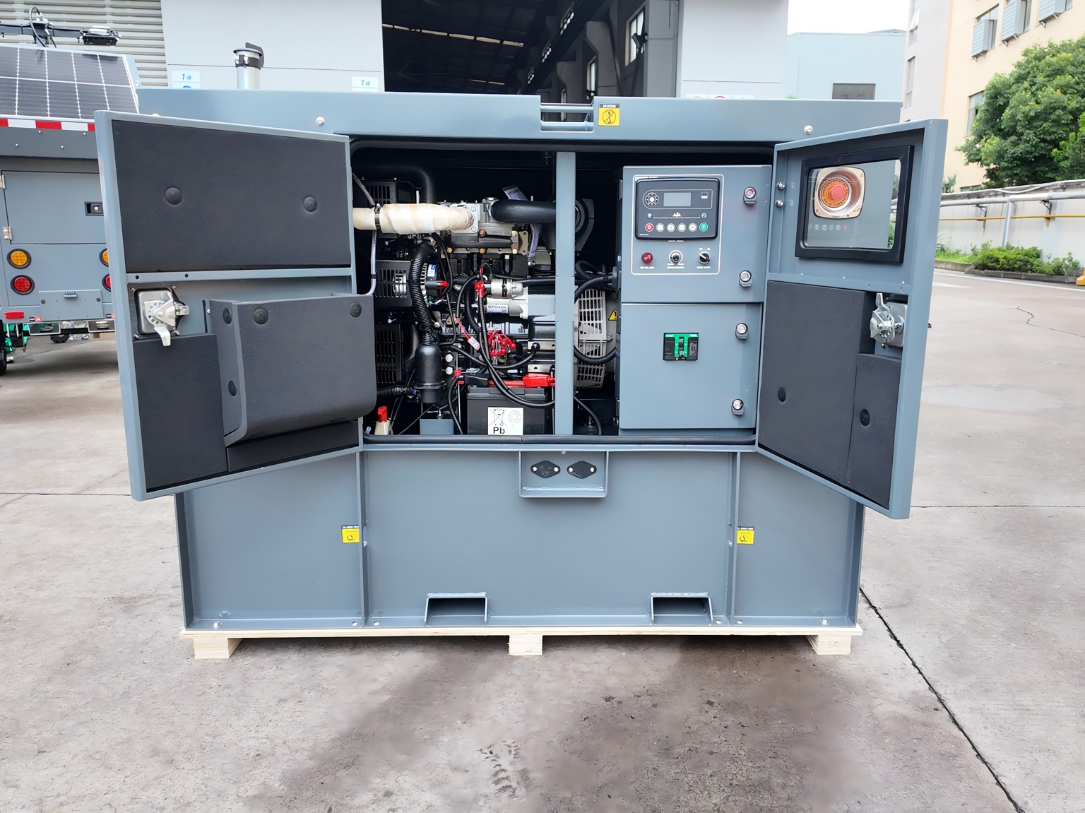Génératrice diesel à caisson gris avec portes ouvertes