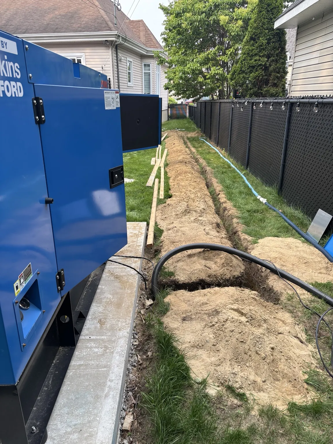 Blue generator and connection conduits alongside a building